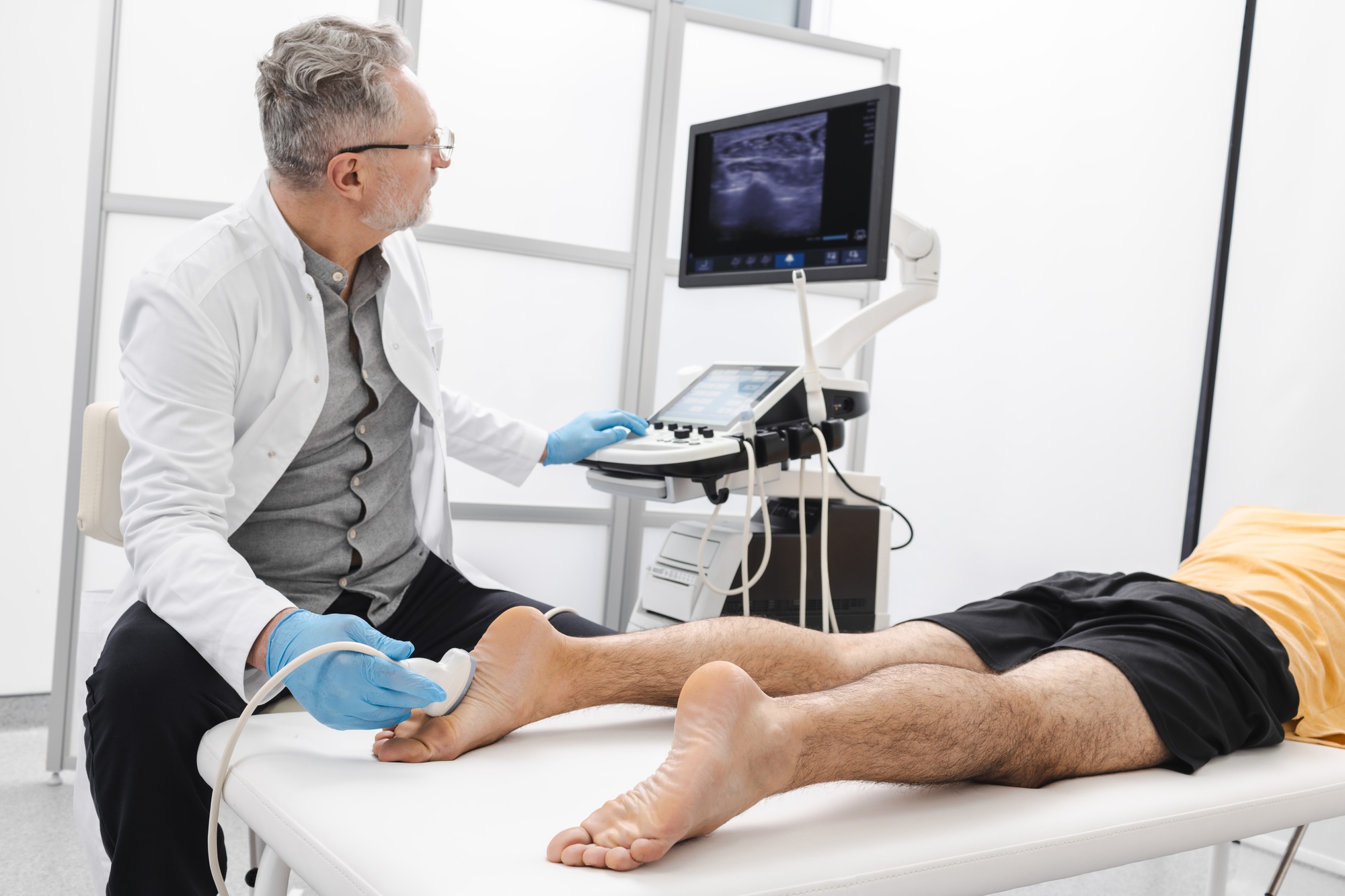 Diagnostic Ultrasound - Man having foot with pain scanned using modern ultrasound machine. Ultrasound of foot and leg