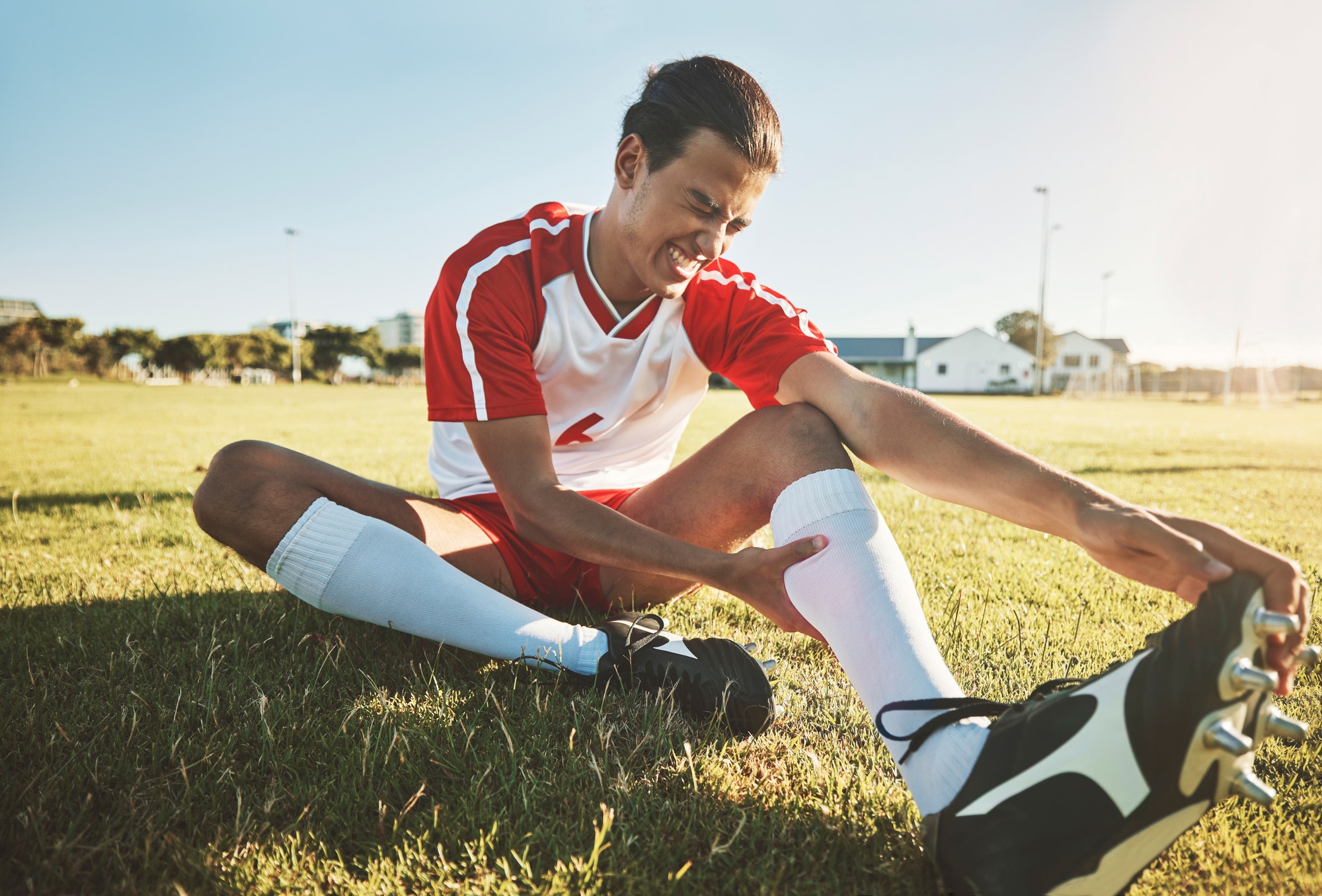 Soccer, athlete and injury on sport field while exercise, workout and practice suffer on game day.