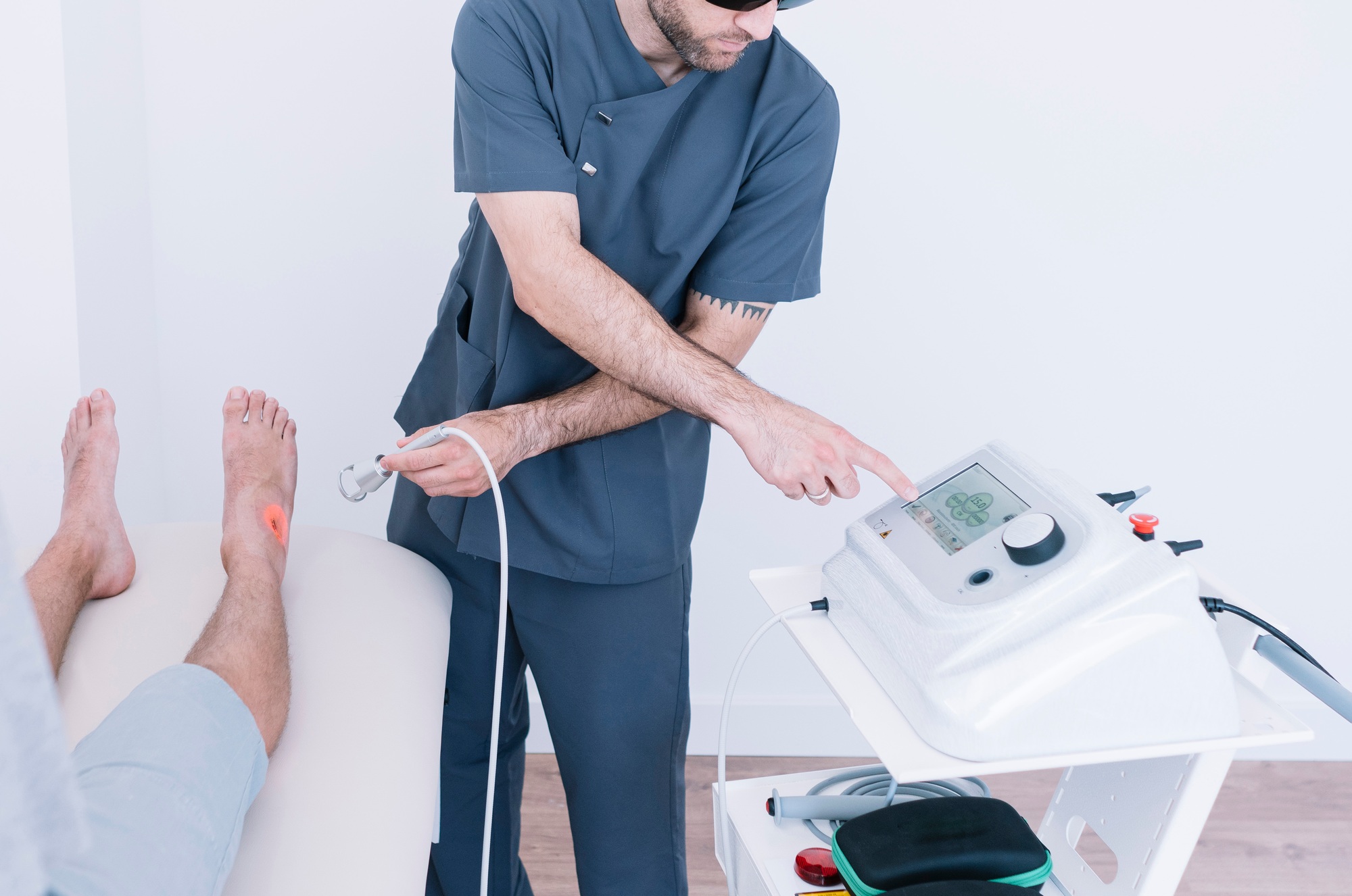 FX635 Laser Therapy - The physiotherapist treating a man using equipment for Laser
